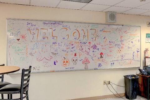 A whiteboard at Eastlake High School shows a student collaboration mural with colorful drawings and “WELCOME” in big letters.
