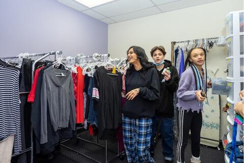Three Eastlake High School students browse the racks of clothing and supplies at the school’s community closet.
