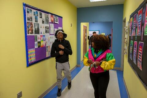 Two students at Eastlake High School walk down the hallway. The hall is brightly painted and clean.