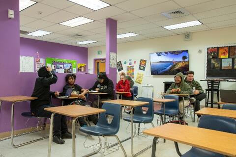 Students at Eastlake High School sit at desks while chatting with each other in a classroom.