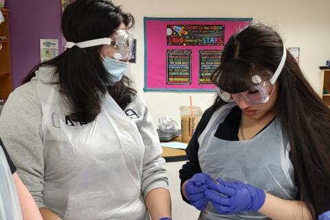 Students wear protective eye gear, aprons, and gloves in Science Class at Eastlake High School in Colorado Springs.