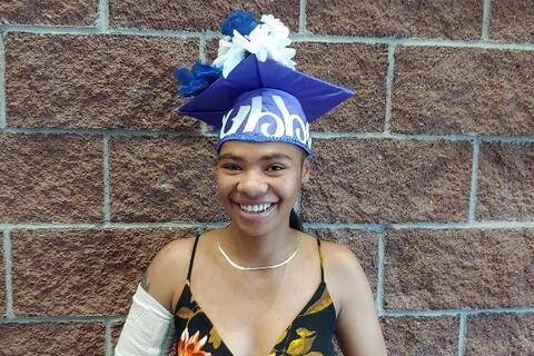 An Eastlake High School graduate wears a customized cap and smiles with joy that she graduated, even with a broken arm.