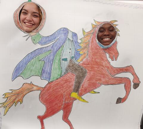 Two Eastlake High School students poke their heads through holes in a large scale drawing of a horse and the headless horseman. The drawing is hand drawn by students.