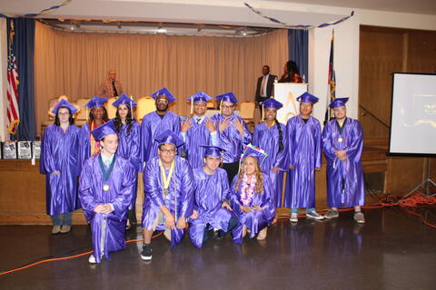 Eastlake High School graduates pose for a photo during the graduation ceremony. They are all wearing royal purple caps and gowns.