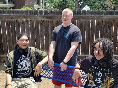 Three Eastlake High School students smile for a photo while socializing outside.