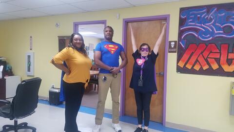Three Eastlake High School staff members pose for a photo. They are dressed as superheroes for the day.