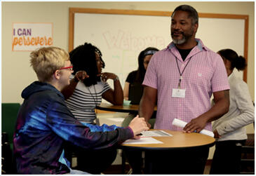 An Eastlake High School teacher speaks with two students in a classroom.